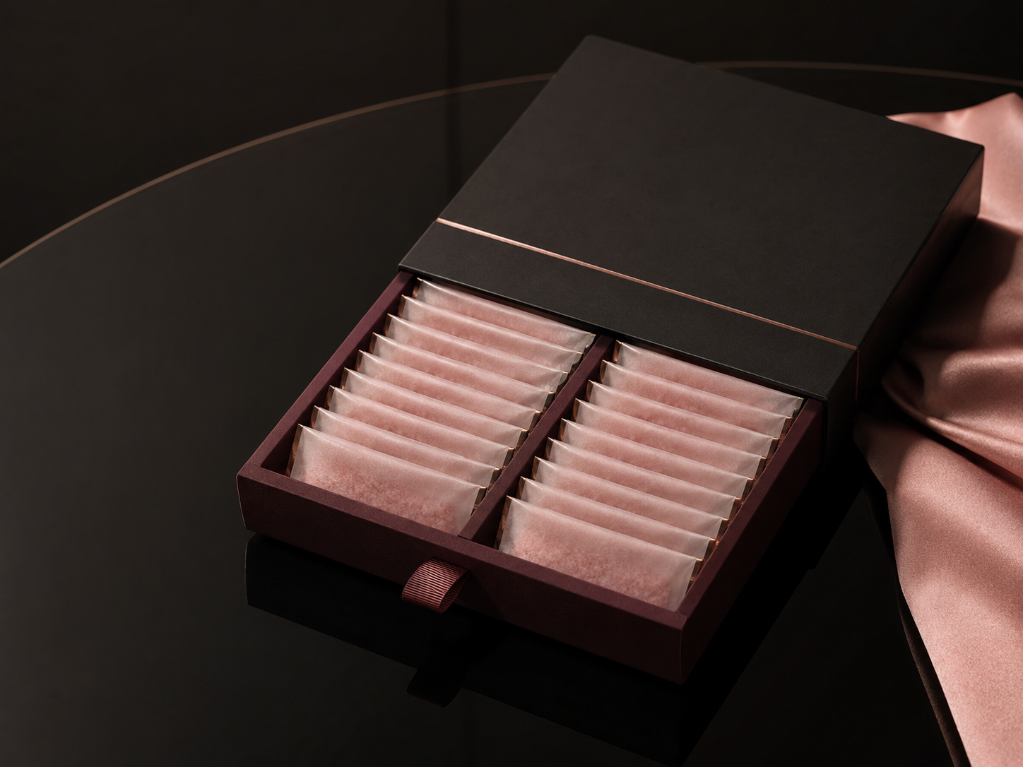 Partially open Daily Couture case with frosted pink salt sachets against nude satin